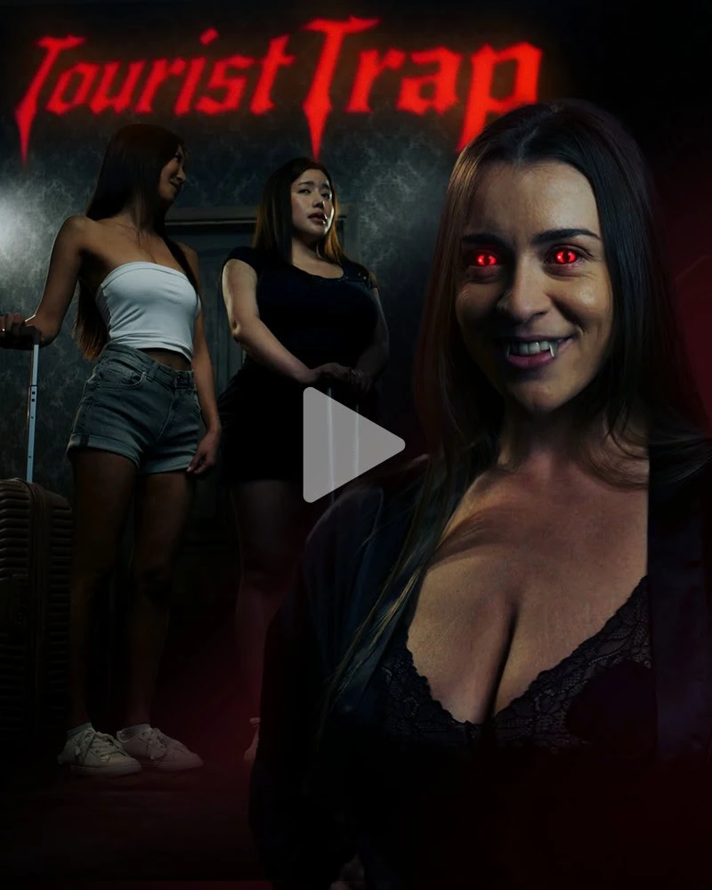 Tourist Trap cover art: a smiling vampire with red eyes in front of two young women